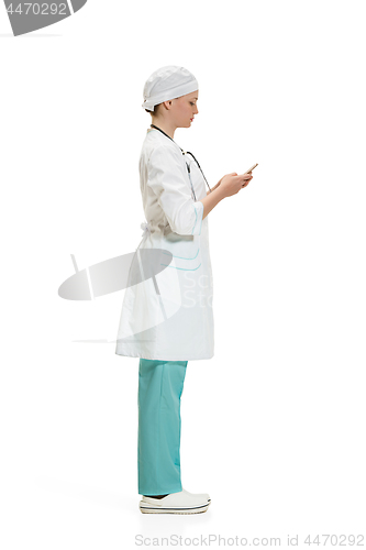 Image of Beautiful young woman in white coat posing at studio. Full length studio shot isolated on white.