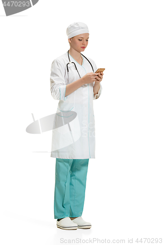 Image of Beautiful young woman in white coat posing at studio. Full length studio shot isolated on white.