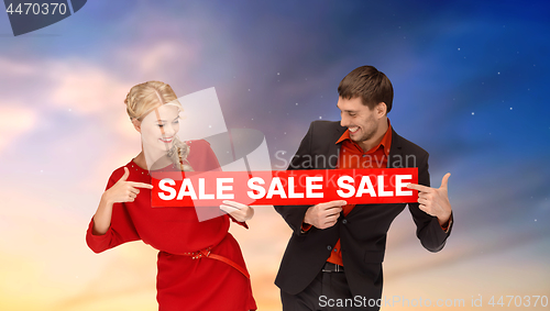 Image of couple with red sale sign