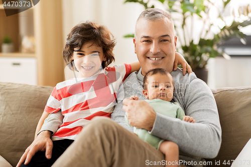 Image of happy father with preteen and baby son at home