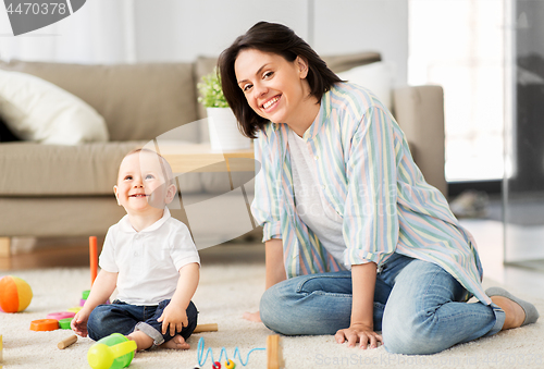 Image of happy mother with little baby son playing at home