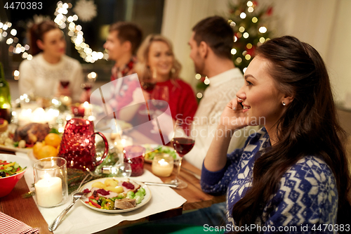 Image of woman calling on smartphone at christmas dinner