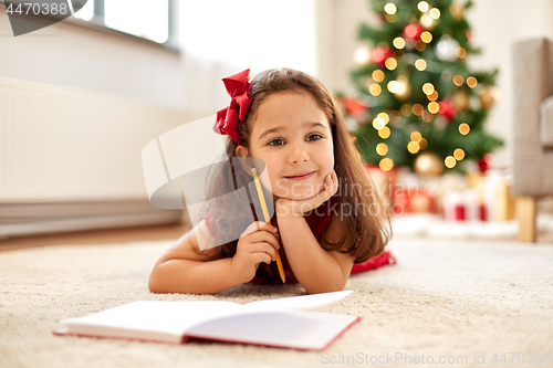 Image of little girl writing christmas wish list at home