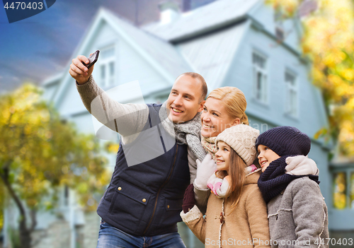 Image of family takes autumn selfie by cellphone over house