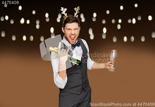 Image of man with bottle of champagne at christmas party