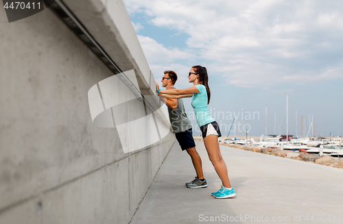 Image of couple with fitness trackers exercising outdoors