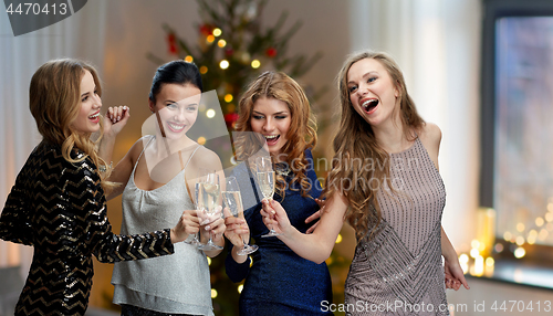 Image of happy women clinking champagne glasses over black