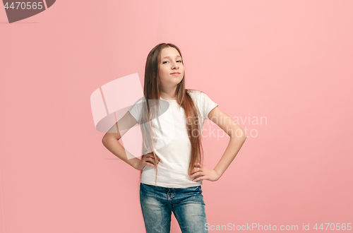 Image of The happy teen girl standing and smiling against pink background.