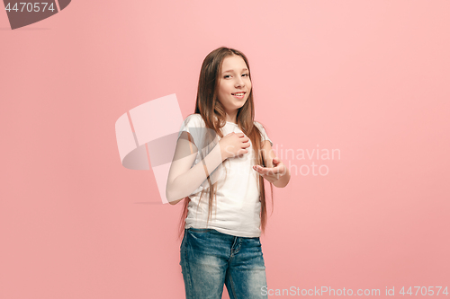 Image of The happy teen girl standing and smiling against pink background.