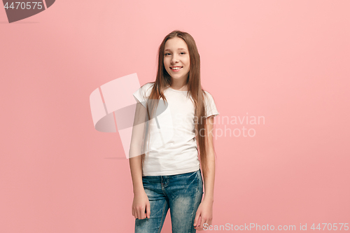 Image of The happy teen girl standing and smiling against pink background.