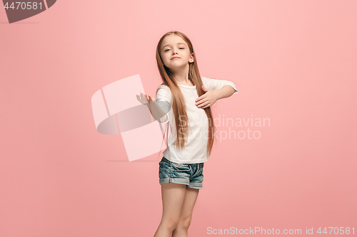 Image of The happy teen girl standing and smiling against pink background.