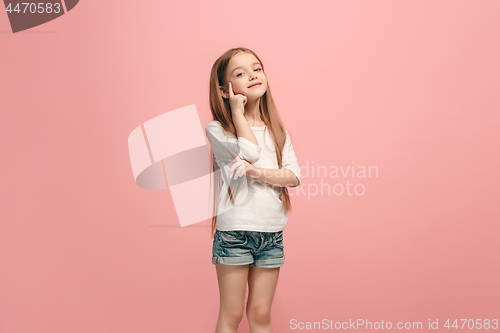 Image of The happy teen girl standing and smiling against pink background.