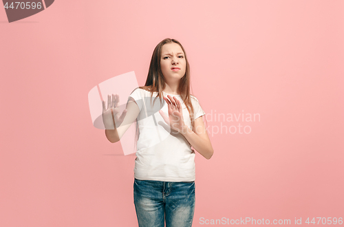 Image of Doubtful pensive teen girl rejecting something against pink background