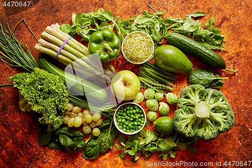 Image of Fresh green vegetables and fruits assortment placed on a rusty metal