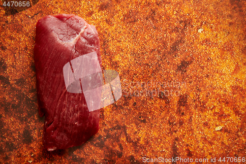 Image of Piece of raw fresh beef steak placed on rusty background