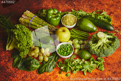 Image of Fresh green vegetables and fruits assortment placed on a rusty metal