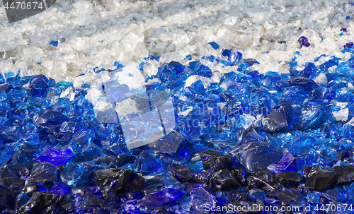 Image of Many broken pieces of glass in white and blue, as background