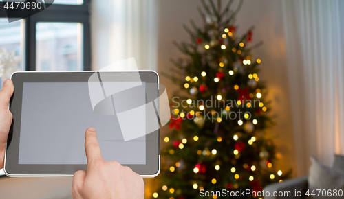 Image of close up of male hands with tablet pc on christmas