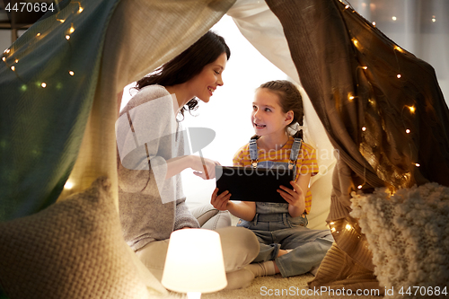 Image of family with tablet pc in kids tent at home