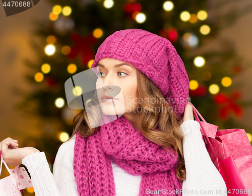 Image of woman with shopping bags over christmas lights
