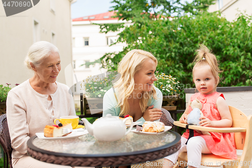 Image of woman with daughter and senior mother at cafe