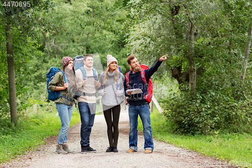 Image of friends or travelers hiking with backpacks and map