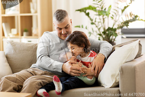 Image of happy father with preteen and baby son at home