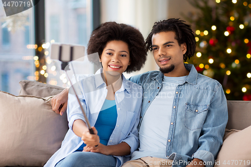 Image of couple with smartphone taking selfie on christmas