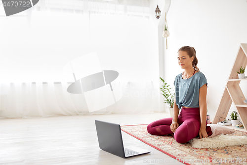 Image of woman with laptop computer at yoga studio