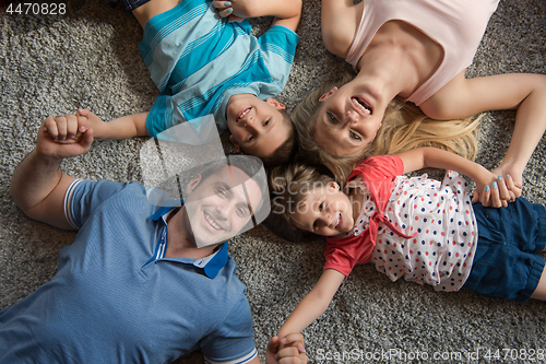 Image of happy family lying on the floor