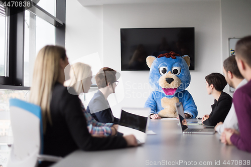 Image of boss dresed as bear having fun with business people in trendy of