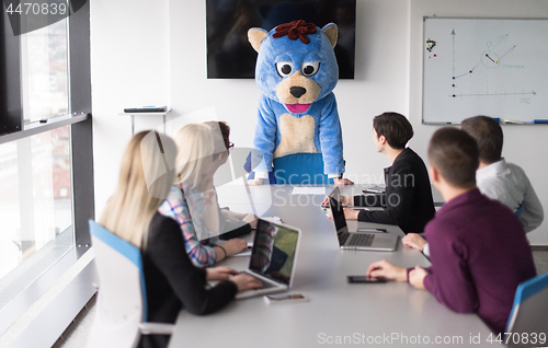 Image of boss dresed as bear having fun with business people in trendy of