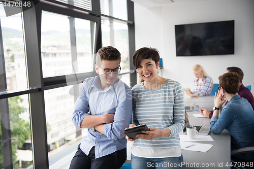 Image of Two Business People Working With Tablet in office