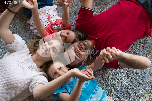 Image of happy family lying on the floor