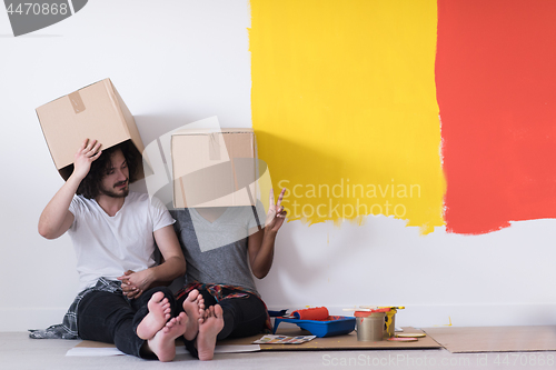 Image of young multiethnic couple playing with cardboard boxes