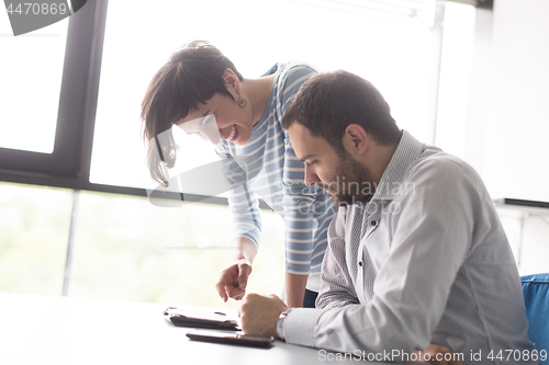 Image of Two Business People Working With Tablet in startup office