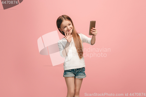 Image of The happy teen girl making selfie photo by mobile phone