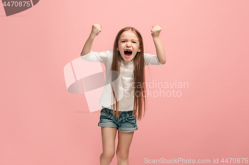 Image of Portrait of angry teen girl on a pink studio background