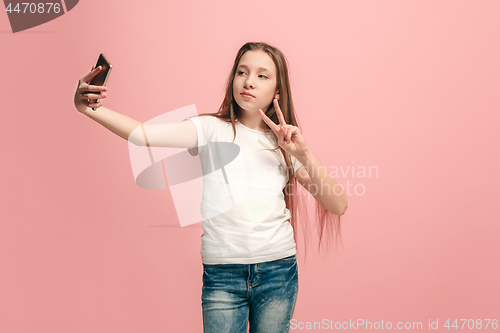 Image of The happy teen girl making selfie photo by mobile phone