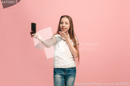 Image of The happy teen girl making selfie photo by mobile phone