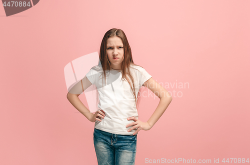 Image of Portrait of angry teen girl on a pink studio background