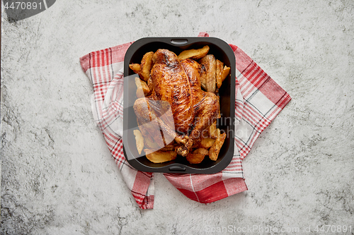 Image of Roasted chicken or turkey with potatoes in black steel mold