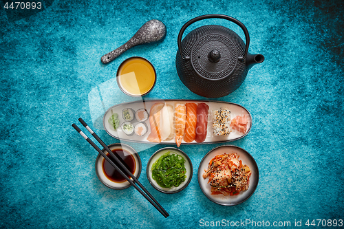 Image of Asian food assortment. Various sushi rolls placed on ceramic plates