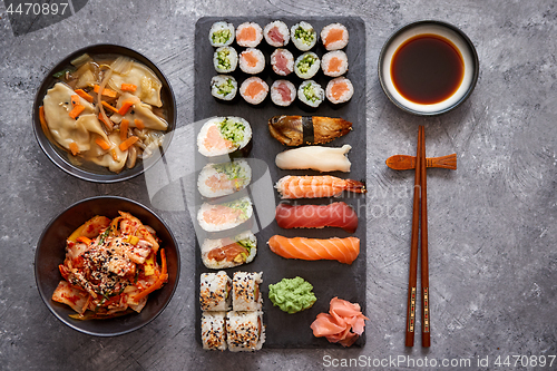 Image of Various kinds of sushi placed on black stone board