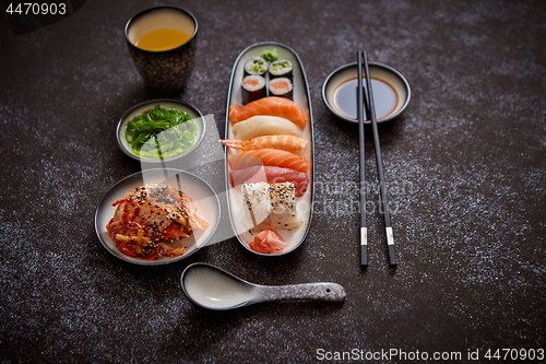 Image of Asian food assortment. Various sushi rolls placed on ceramic plates