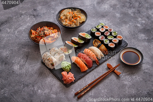 Image of Various kinds of sushi placed on black stone board