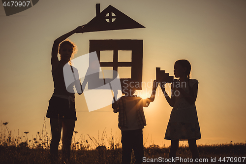 Image of Happy children standing on the field at the sunset time.