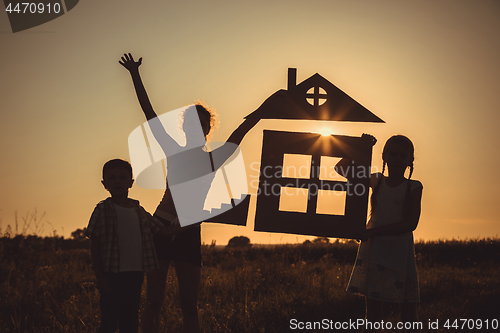 Image of Happy children standing on the field at the sunset time.