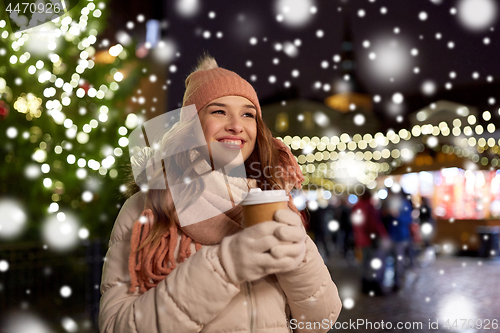 Image of happy young woman with coffee at christmas market