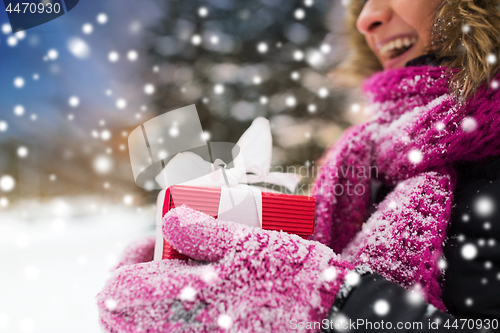 Image of close up of woman with christmas gift outdoors